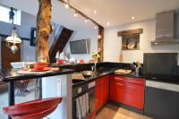 a kitchen with red cabinets and a black counter top at La porcherie du pet en l&#39;air in Saint Malo