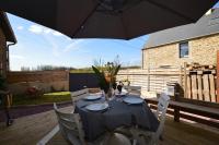 a table with chairs and an umbrella on a deck at La porcherie du pet en l&#39;air in Saint Malo