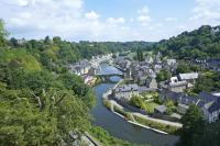 a river flowing through a town with a bridge at La porcherie du pet en l&#39;air in Saint Malo