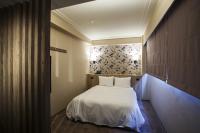 a bedroom with a white bed and a wall at Citizen Hotel in Taipei