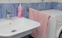 a bathroom with a sink and a washing machine at Apartmani Krmek in Mlini