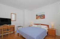 a bedroom with a bed and a flat screen tv at Apartmani Krmek in Mlini