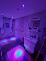 a bathroom with purple and pink lights and a sink at Chambres d&#39;hôtes avec jacuzzi privatif in Westrehem