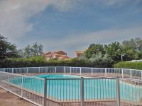 a swimming pool with a fence around it at Lagrange Vacances Le Scarlett et Les Soleillades in Palavas-les-Flots