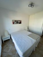 a bedroom with a white bed in a room at Résidence quai St Louis Villa t4 pour 6 personnes N1 47 in Aigues-Mortes