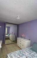 a bedroom with purple walls and a bed and a mirror at La Violette ONLY WOMEN femmes uniquement in Vénissieux