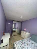 a bedroom with purple walls and a bed and a mirror at La Violette ONLY WOMEN femmes uniquement in Vénissieux