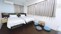 a bedroom with two beds and a table and a stool at Sun B&amp;B in Taitung City