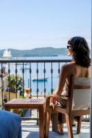 a woman sitting in a chair at a table overlooking the water at Casa Manor Boutique Hotel in Tivat