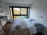 a bedroom with a bed with a large window at Maginifique villa d&#39;architecte sur les bords de Marne tout près de Paris in Le Perreux-Sur-Marne