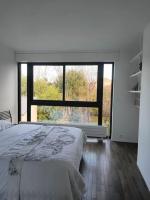 a bedroom with a bed and a large window at Maginifique villa d&#39;architecte sur les bords de Marne tout près de Paris in Le Perreux-Sur-Marne