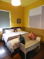 a yellow bedroom with a bed with a bench at Home in Hengchun Homestay in Hengchun South Gate