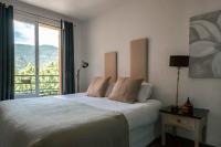 a bedroom with a bed and a large window at Surplage Hotel Cavalière in Le Lavandou