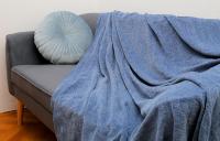 a blue blanket on a couch with a pillow at Apartmani Krmek in Mlini