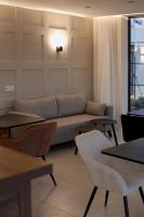 un soggiorno con divano, tavoli e finestra di Salento Winery Lodge a San Pietro in Bevagna