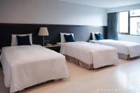 a hotel room with two beds with blue pillows at Talmud Hotel Kaohsiung LoveRiver in Kaohsiung