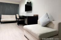 a living room with a couch and a desk at Talmud Hotel Kaohsiung LoveRiver in Kaohsiung