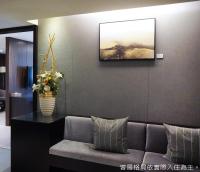 a living room with a couch and a painting on the wall at Talmud Hotel Kaohsiung LoveRiver in Kaohsiung