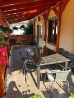 a patio with a table and chairs on a porch at Căsuța din pădure de la Câmpu lui Neag in Cîmpu lui Neag