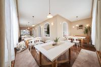 Un comedor con mesas y sillas blancas. en Breitenfelderhof zur Riegersburg, en Breitenfeld an der Rittschein