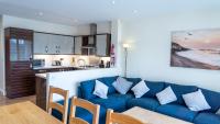 ein Wohnzimmer mit einer blauen Couch und einer Küche in der Unterkunft Tewitfield Marina in Carnforth