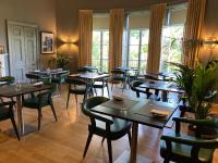 um restaurante com mesas, cadeiras e janelas em Grays Court Hotel em York