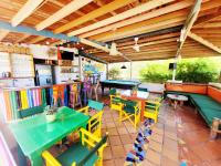 een restaurant met tafels en stoelen en een bar bij Divanga Hostel and Diving in Taganga