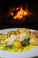 Un plato de comida con un trozo de pollo y patatas. en Pedras D'el Rei, en Tavira