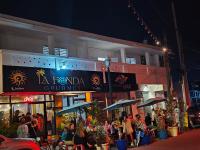 un grupo de personas sentadas fuera de un edificio con sombrillas en Casa Maria Luquillo PR, en Luquillo