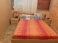 a bedroom with a bed with an orange comforter and pillows at Nice Fabron 90 m2 avec Garage in Nice