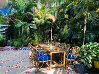 a wooden table and chairs in a courtyard with palm trees at Swati in Arambol