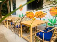 two tables and chairs in front of a wall with flowers at Swati in Arambol