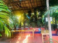 a table and benches in a room with plants at Swati in Arambol