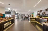 eine große Küche mit einer Cafeteria, die reichlich Essen anbietet in der Unterkunft Ramada Plaza By Wyndham Batman in Batman