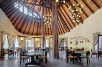 una sala da pranzo con tavoli, sedie e un grande soffitto di Nofa Riyadh, A Radisson Collection Resort a Ţibrāk