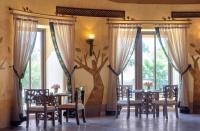 una sala da pranzo con tavoli, sedie e finestre di Nofa Riyadh, A Radisson Collection Resort a Ţibrāk