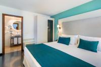 A bed or beds in a room at Occidental Pueblo Acantilado