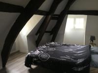 a bedroom with a bed with a black comforter at Bel appartement dans petite citée de caractère in Tréguier