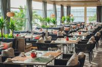 Un restaurante con mesas, sillas y ventanas. en D - Resort Ayvalık, en Ayvalık