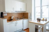 a kitchen with white cabinets and a wooden counter top at La Mésange Huppée #8 Gare in Quimper