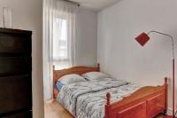 a bedroom with a bed and a lamp and a window at Le Charlemagne- Boulogne in Boulogne-Billancourt