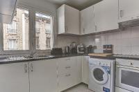 a white kitchen with a washing machine in it at Le Charlemagne- Boulogne in Boulogne-Billancourt