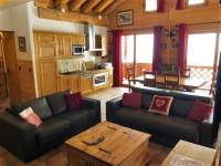 a living room with two couches and a table at L&#39;Aiglon - spacious 2-bedroom apartment with log fire in Sainte-Foy-Tarentaise
