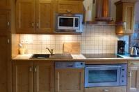 a kitchen with a sink and a microwave at L&#39;Aiglon - spacious 2-bedroom apartment with log fire in Sainte-Foy-Tarentaise