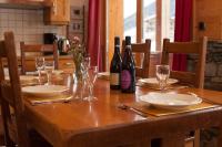 a wooden table with wine bottles and glasses on it at L&#39;Aiglon - spacious 2-bedroom apartment with log fire in Sainte-Foy-Tarentaise