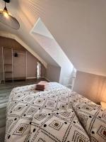a bedroom with a large bed in a attic at Élégante &amp; Design Casa Churchill - Brive Centre in Brive-la-Gaillarde