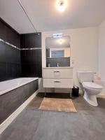 a bathroom with a sink and a toilet and a bath tub at Élégante &amp; Design Casa Churchill - Brive Centre in Brive-la-Gaillarde