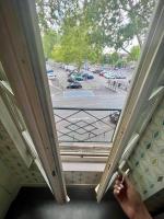 a person looking out of a window at a parking lot at Élégante &amp; Design Casa Churchill - Brive Centre in Brive-la-Gaillarde