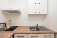 a kitchen with a sink and white cabinets at Casa Lyon Cosy 1 Br Flat Part Dieu in Lyon