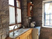 a kitchen with a sink and two windows at Kastraki Art Houses in Kousounárion